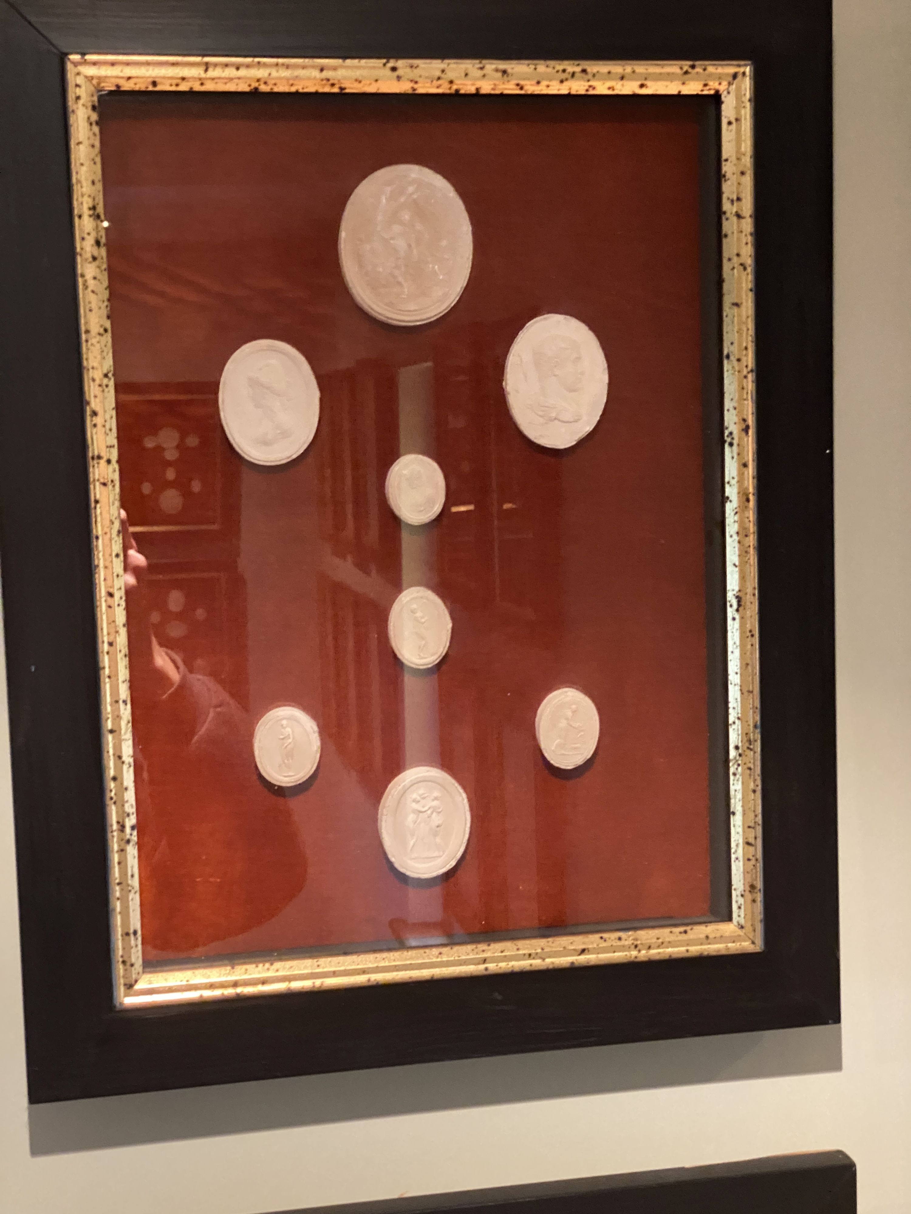 A collection of thirty four framed reproduction plaster intaglios, on velvet backing with parcel gilt ebonised frames, overall 45 x 35cm